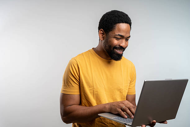 istock Confident male entrepreneur analyzing report over laptop while standing over white background 2238357972