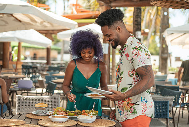 istock Afro couple serving food at a tropical restaurant 2238358866
