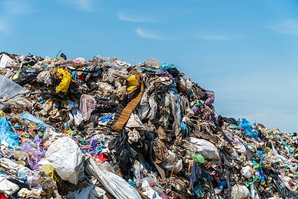 istock A massive mound of trash filled with plastic, fabric, and other debris is seen against a bright blue sky, highlighting waste management issues 2238360042