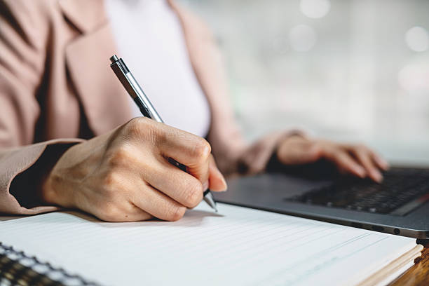 istock Company employee writing on notebook with working on laptop computer in office. Business planning concept 2238370277