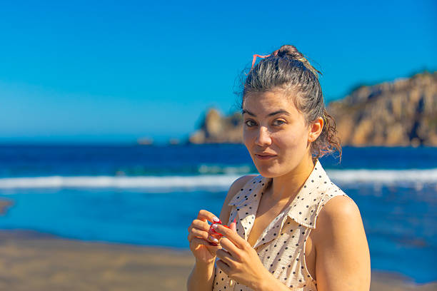 portrait of a young woman on the beach in profile, walking relaxed whit dress