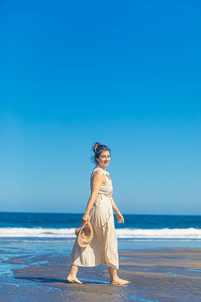 istock young woman walking on the beach whit hat 2238370908