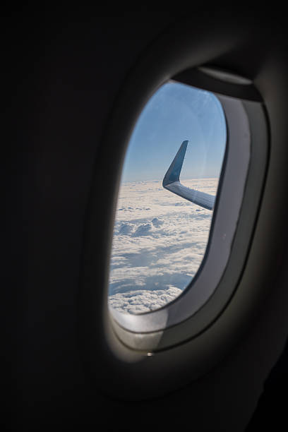 istock Airplane Wing Seen Through Passenger Window Above Clouds 2238373186