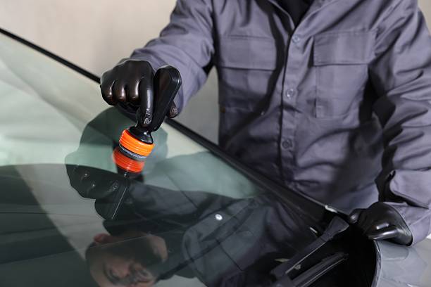 istock Man polishing car windshield indoors, closeup view 2238373340