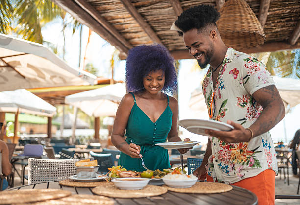 istock Afro couple serving food in a beachside restaurant 2238374846