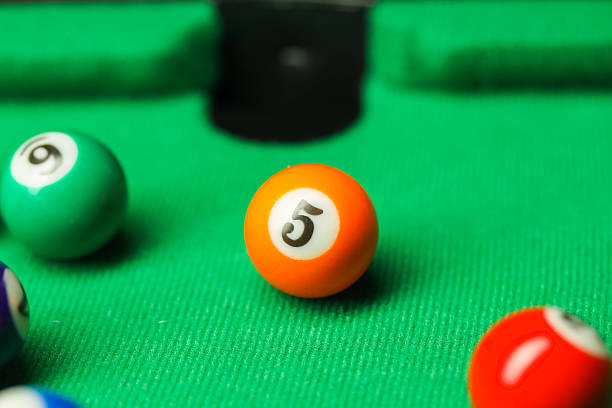 Many colorful billiard balls on green table, closeup