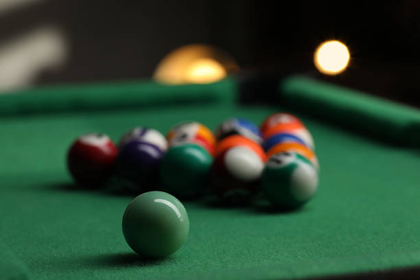 Strong hit by a player with a billiard cue on the ball on green table