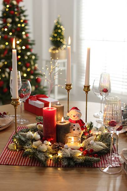 Christmas place setting with festive decor on wooden table in room