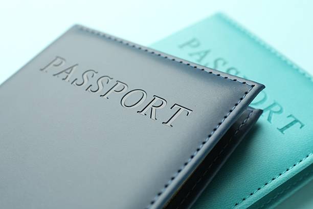 istock Passports in color covers on light blue background, closeup 2238378379