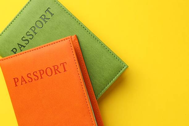 istock Passports in color covers on yellow background, top view. Space for text 2238378451