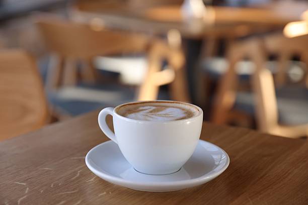istock Cup of aromatic coffee on wooden table in cafe, closeup. Space for text 2238380942