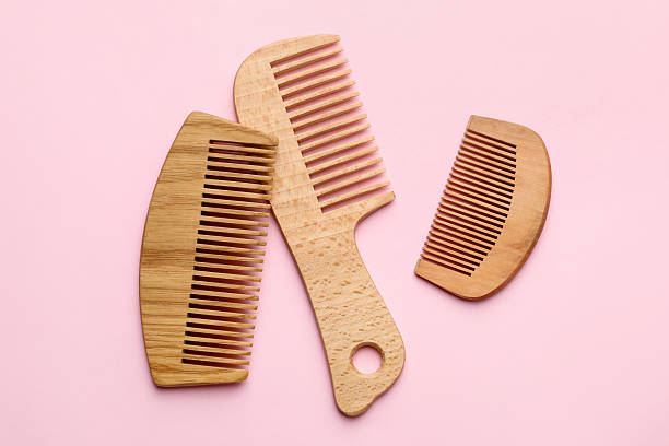istock Different wooden hair combs on pink background, top view 2238382352