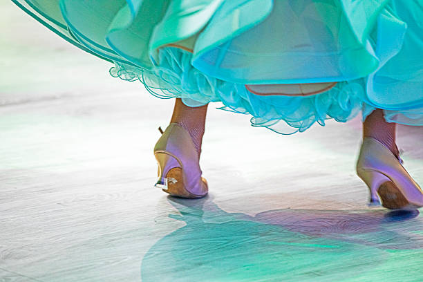 Young ladies in delicate, fluffy dresses dance a standard program on the floor