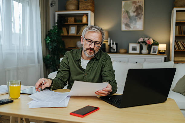 istock Man working from home, reviewing paperwork and finance 2238389473