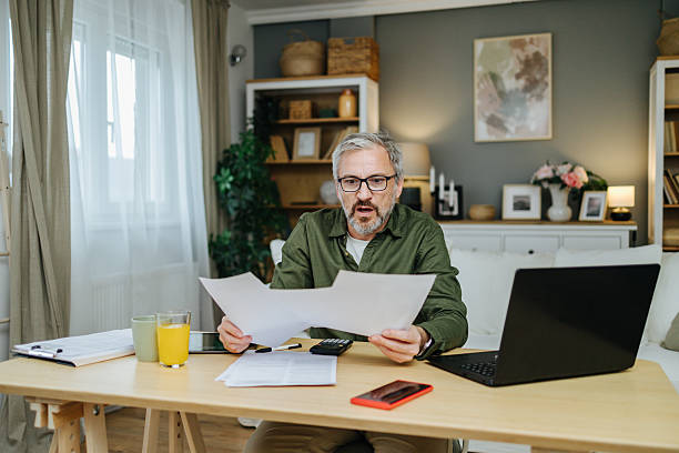 istock Mature man calculating finances, feeling shocked and stressed 2238389622