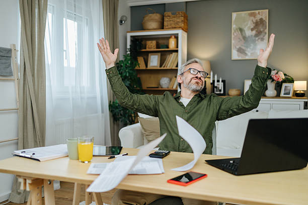 istock Overwhelmed man throwing papers working from home 2238389662