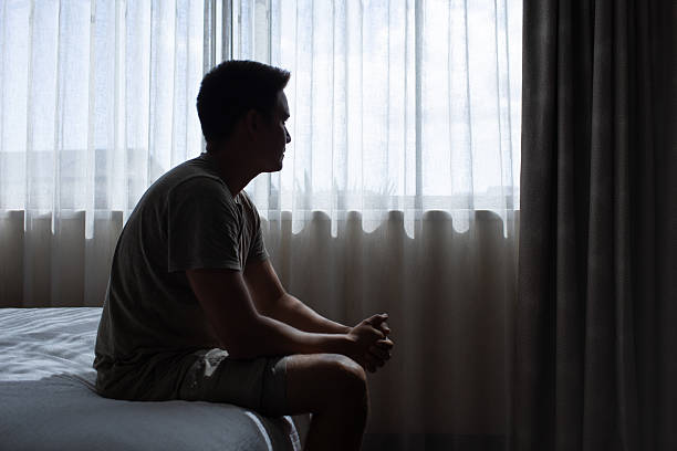 istock Thoughtful sad man sitting on the bed thinking about his future. Heartbroken man missing his love. 2238390647