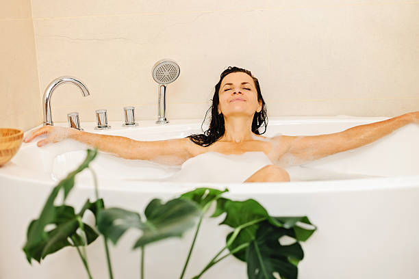 istock Tranquil Woman Relaxing In Bubble Bath With Open Arms In Modern Spa Bathroom 2238391379