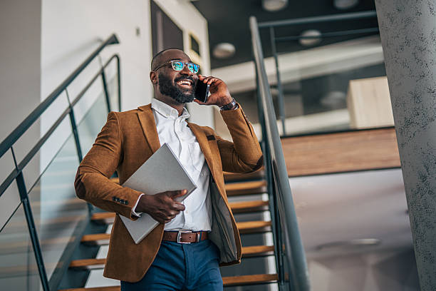 istock Professional man talking on phone walking up stairs 2238392956