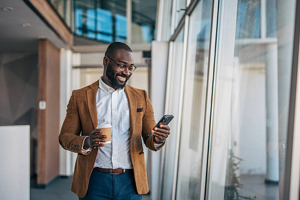istock African american businessman smiling using smartphone and drinking coffee 2238393070