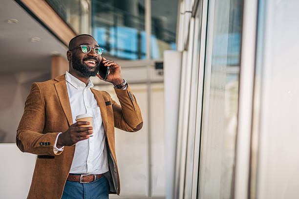 istock Happy young black businessman talking on cell phone with coffee 2238393239