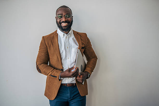 istock Smart black businessman holding laptop smiling at camera 2238394621