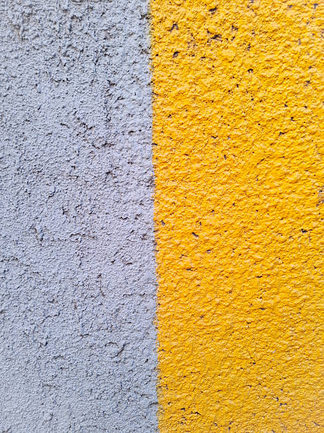 istock Yellow and dirty white concrete wall, full frame. Colorful wall close up. 2238394656