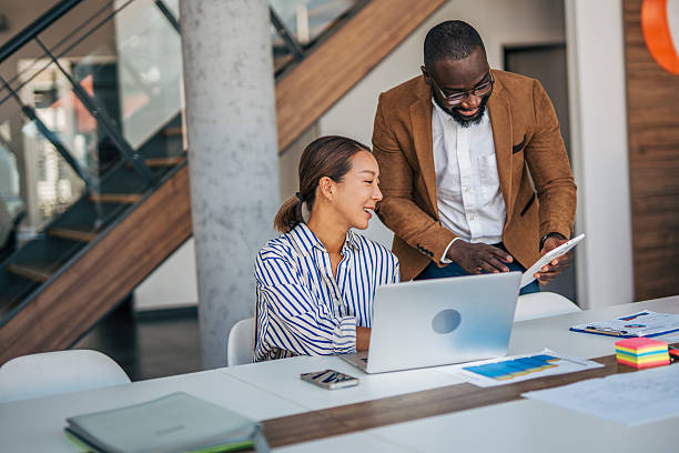 istock Diverse business colleagues collaborating on tablet and laptop in office 2238395190