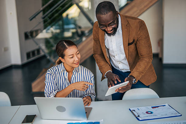istock Diverse business professionals collaborating on digital tablet in office 2238395329