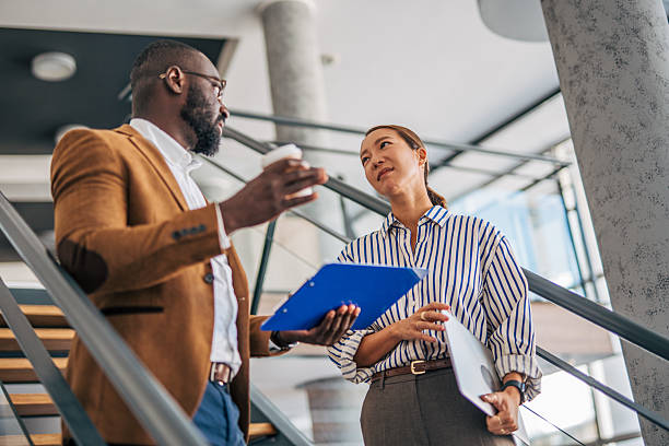 istock Business colleagues having a conversing on modern office stairs 2238396989