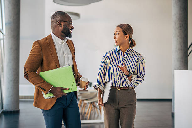 istock Diverse business colleagues walking and having conversation in modern office 2238397067