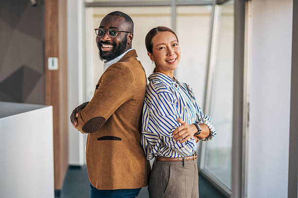 istock Diverse business partners standing back to back smiling confidently 2238399156