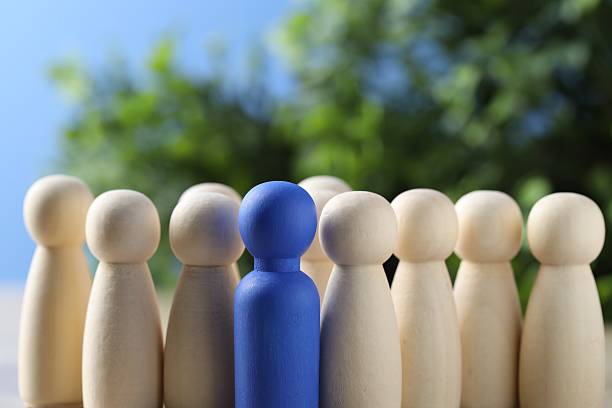 istock Human resources concept. Blue figure among wooden ones on table against blurred background, closeup. Space for text 2238399515