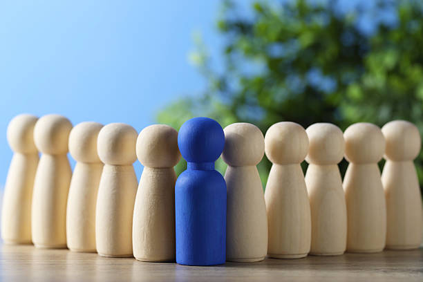 istock Human resources concept. Blue figure among wooden ones on table against blurred background, closeup. Space for text 2238399599