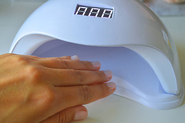 istock Woman's Hand Under UV Nail Lamp 2238400644