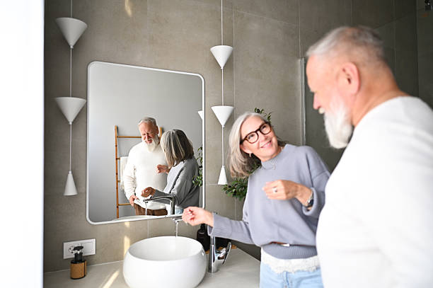 istock Senior couple sharing a happy morning routine in modern bathroom 2238400950