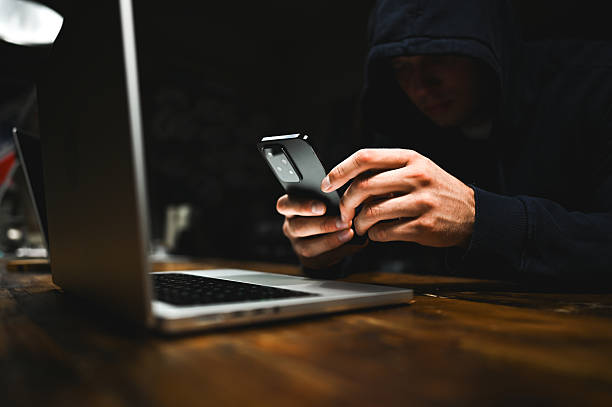istock Hacker using smartphone and laptop in dark room. wannacry ransomware attack 2238402804