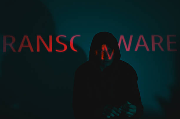 istock Hooded hacker standing in front of ransomware text. wannacry ransomware attack 2238402892