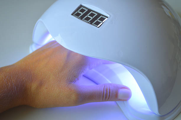 istock Hand Under UV Nail Lamp with LED Timer Display During Gel Nail Curing 2238402900