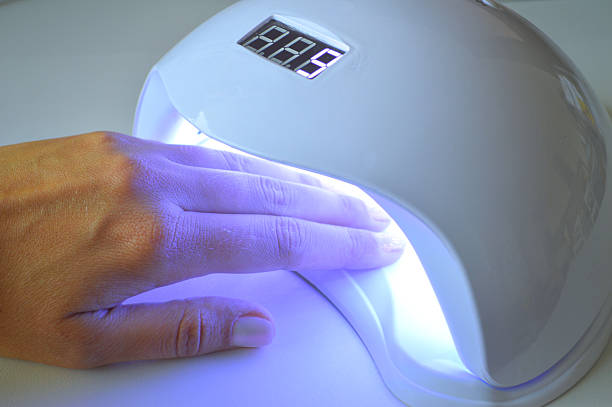 istock Hand Under UV Nail Lamp with LED Timer Display During Gel Nail Curing 2238403047