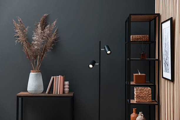 istock Console table with decor, shelving unit and lamp near grey wall in room. Interior design 2238403120