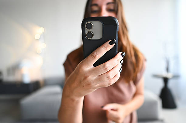 istock Woman holding smartphone vlogging or taking selfie at home 2238403174