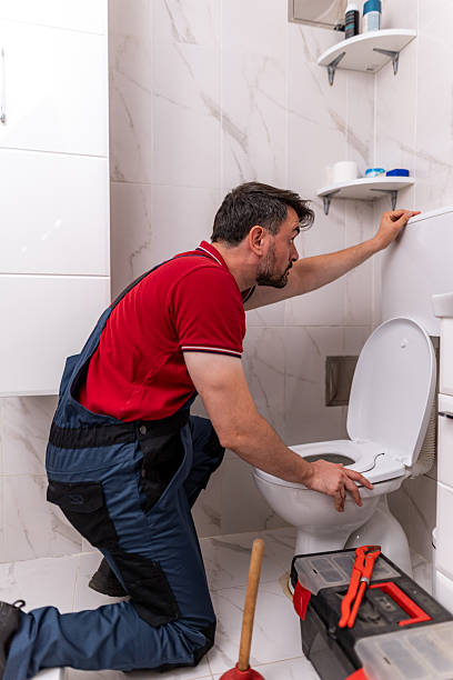 istock Man repairs a toilet in a modern bathroom using tools and a plunger 2238412823