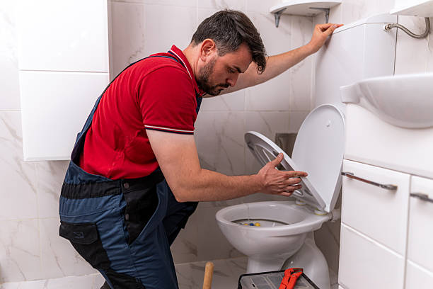istock Plumber fixing a toilet in a modern bathroom using tools and skills for repair work 2238412830