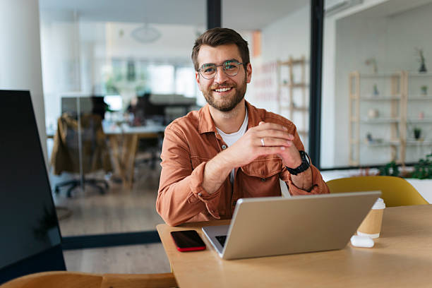 istock Professional man smiling at desk working on laptop 2238413244