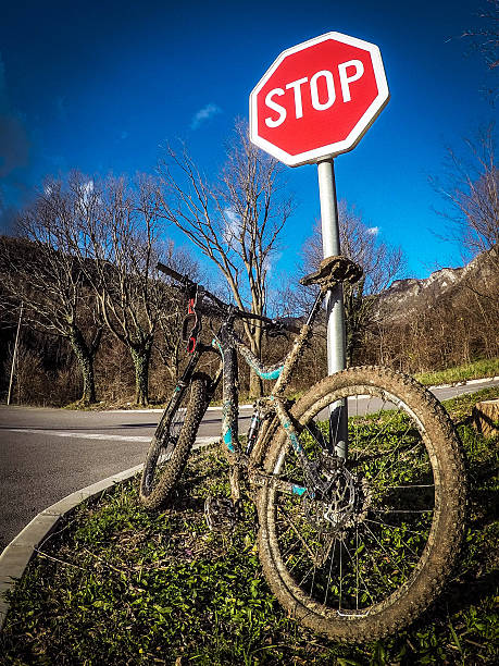 Muddy downhill bicycle parked at the stop sign after a ride