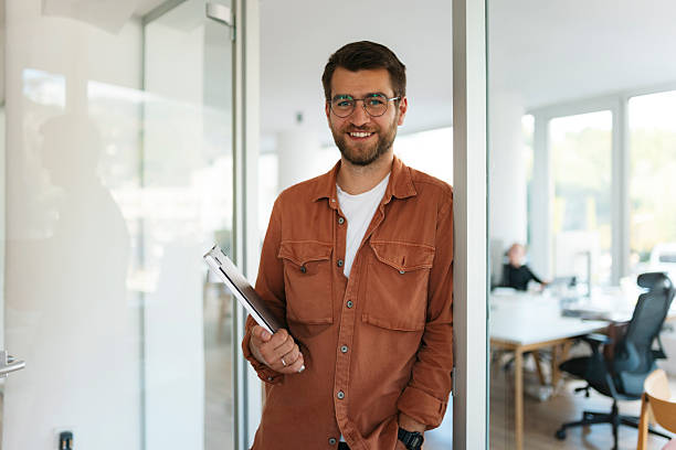 istock Happy young businessman smiling in modern office 2238419159