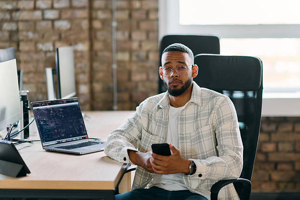 istock African American entrepreneur takes a break in a modern office, using a smartphone to browse social media, capturing a moment of digital connectivity and relaxation amidst his business endeavors. 2238419309