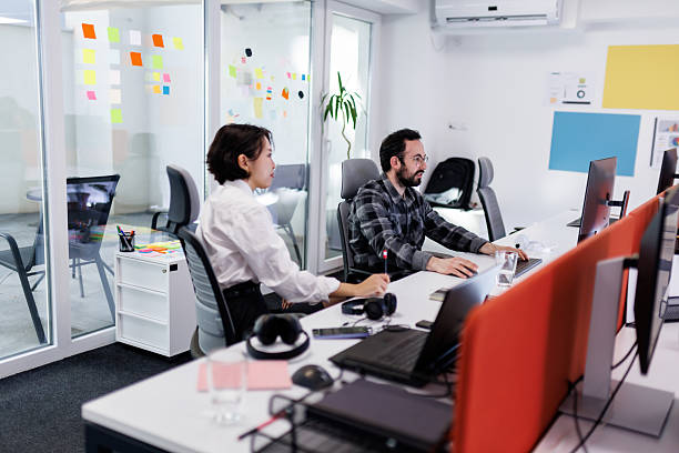 istock Business professionals collaborate in a modern office workspace with technology and colorful notes during a productive work session 2238424285