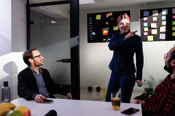 istock Business team collaborating in a modern office discussing strategies with notes on the wall and engaging in dynamic conversation 2238424371